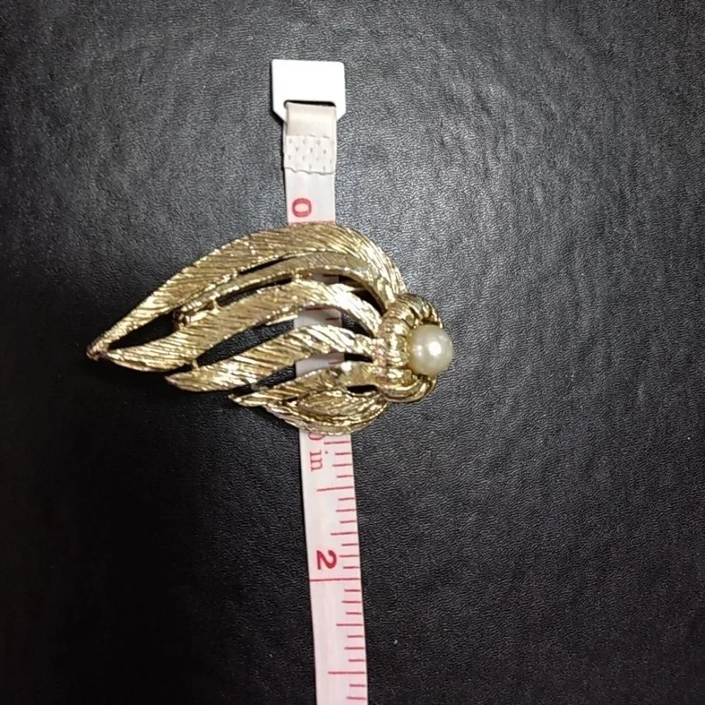 Gold tone brooch with faux pearl